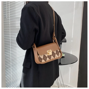 Close-up of vintage argyle saddle bag with gold buckle and brown leather flap detail