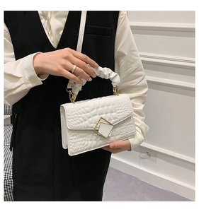 Détail du sac à bandoulière blanc texture crocodile avec poignée plissée et boucle métal
