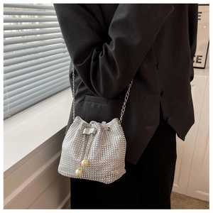 Detail of silver rhinestone bucket bag with chain strap and pearl drawstring accents