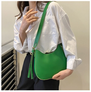 Side view of bright green leather hobo bag with adjustable strap and metal hardware