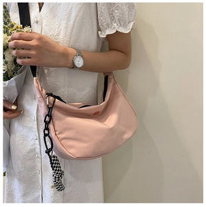 Sac croissant rose avec large bandoulière noire et pendentif en damier chic
