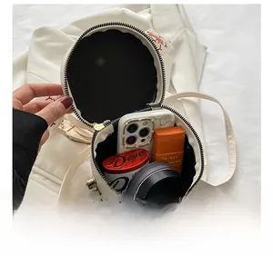 Detail view showing spacious interior storage of the white circular crossbody bucket bag