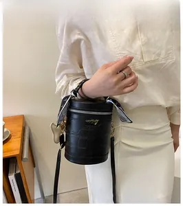 Detail of black faux crocodile bucket bag with silk scarf handle and cloud charm