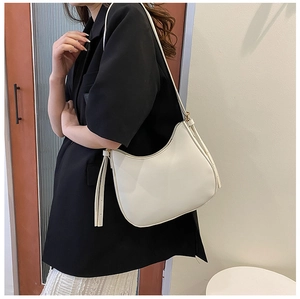 Minimalist white leather crescent shoulder bag styled with black blazer and lace dress