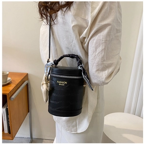 Detail of black croc-embossed bucket bag with silk scarf handle and white coin purse