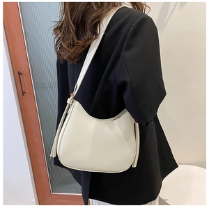 Chic cream-colored hobo shoulder bag styled with a professional black suit outfit
