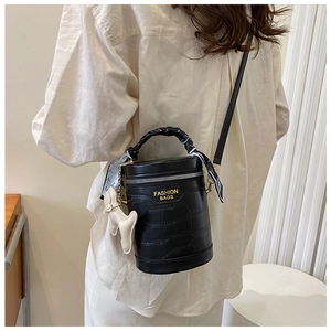 Detail of black crocodile texture bucket bag with silk scarf handle and puppy charm