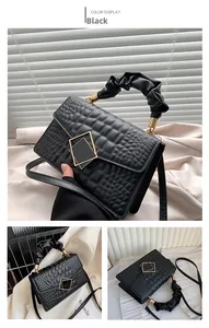 Détails du sac noir motif crocodile avec poignée plissée et boucle métallique dorée