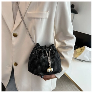 Detail of a black rhinestone mini bucket bag with pearl tassels and silver chain