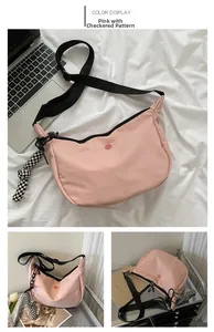 Sac bandoulière rose en nylon avec sangle noire et pendentif damier dans divers décors