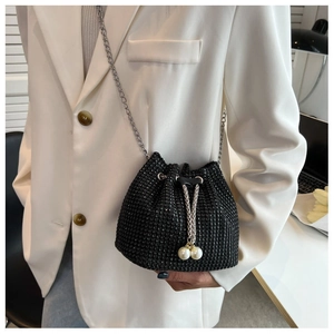 Detail of black rhinestone bucket bag with shiny crystal embellishments and pearl charms