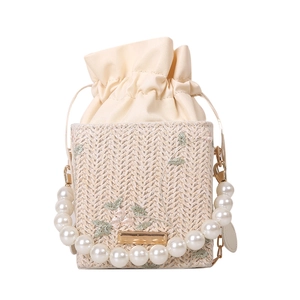 Petit sac seau en paille avec broderie florale, anse en perles et fermeture à cordon