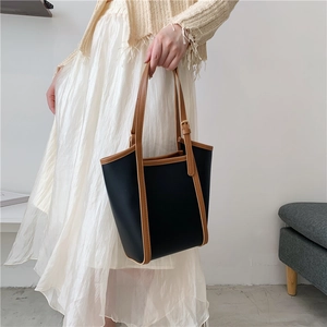 Black and brown tote bag for women shown as a model shoulder bag for daily commute
