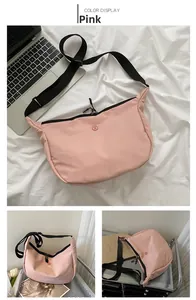 Détail du sac bandoulière en nylon rose avec sangle réglable et fermeture éclair