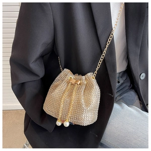 Detail of gold rhinestone bucket bag featuring drawstring closure and pearl accents