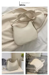 Detailed view of cream white crescent shoulder bag with smooth matte finish and gold hardware