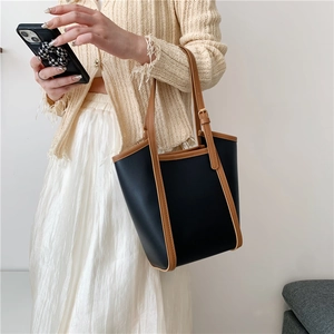 Large capacity tote bag in black and brown contrast leather with adjustable top handle