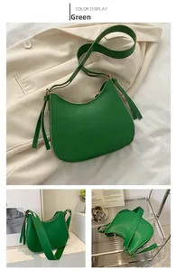 Detail view of bright green minimalist half-moon crossbody bag with wide shoulder strap