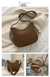Detail view of dark brown leather half-moon saddle bag with a decorative side knot
