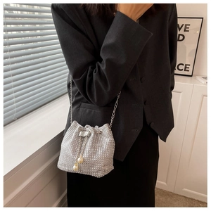 Detail of silver rhinestone bucket bag with chain strap and pearl drawstring closure
