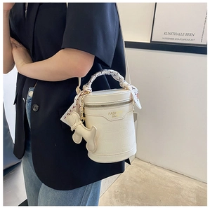 Detail of white crocodile texture bucket bag with printed silk scarf handle and gold lettering