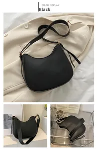 Close-up of black matte leather crescent moon bag with zipper detail and adjustable strap
