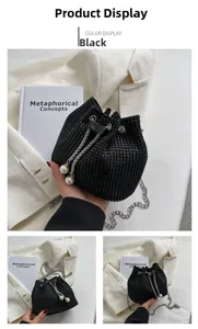 Detail of black rhinestone bucket bag with silver chain and pearl drawstring charms