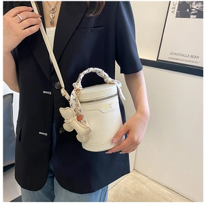 Detail of white crocodile pattern bucket bag with printed scarf handle and bone charm