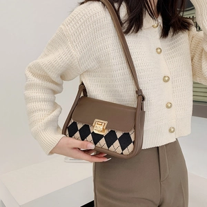 Retro argyle pattern saddle bag with gold buckle shown on shoulder for classic look