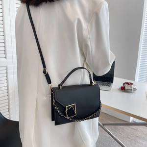 Chic black minimalist crossbody bag with gold geometric buckle and metallic chain strap
