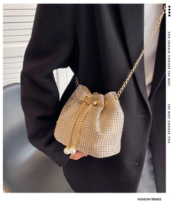 Detail of gold rhinestone bucket bag with pearl drawstring charms and gold chain strap