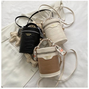 Detail of crocodile texture bucket bags in black white and khaki with silk scarves