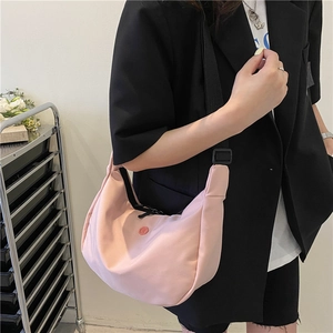 Sac bandoulière en nylon rose en forme de croissant avec sangle large et logo rond minimaliste