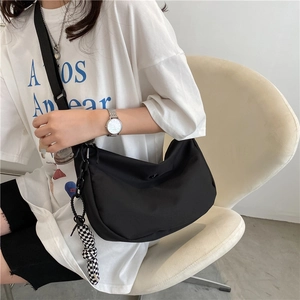 Sac bandoulière noir en forme de croissant avec sangle réglable et breloque damier