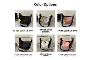 Detail view of nylon crossbody dumpling bags in black, white and pink with flower charms