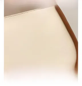 Detailed close-up of cream leather texture with brown edge paint on the shoulder bag