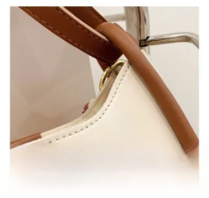 Detailed view of high-quality stitching on minimalist beige pebbled leather bucket bag