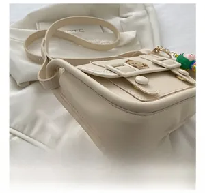 Detail view of precise stitching on cream small crossbody bag with cute dog embroidery