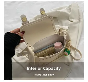 Internal capacity of off-white crossbody bag showing phone, wallet, and makeup storage