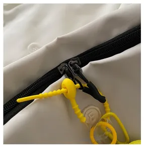 Detail of white nylon bag showing smooth double black zippers with yellow silicone pull cords