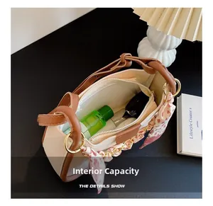 Top view of beige bucket bag internal capacity with cosmetics and leopard scarf