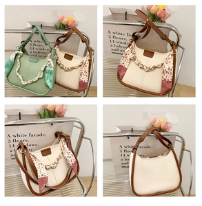 Detail of PU leather bucket bag with silk scarf handle and metal chain decoration
