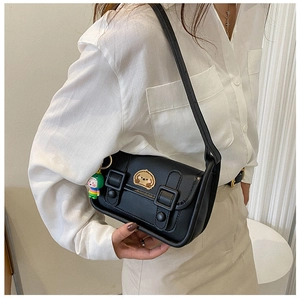 Detail of a black leather crossbody bag with dual buckles and a cute puppy embroidery