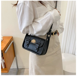 Detail of black crossbody bag with adjustable strap and cute cartoon dog patch