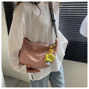 Detail of pink nylon half-moon crossbody bag with adjustable strap and sunflower charm