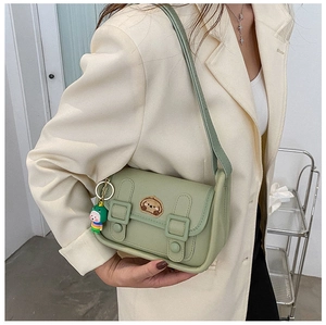 Detailed view of light green crossbody bag with puppy patch and decorative charm