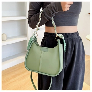 Mint green crescent shoulder bag with silk scarf handle on a female model