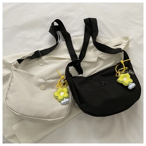 Detail of black and beige crescent crossbody bags with vibrant yellow sunflower charms