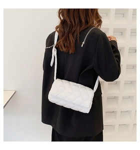 Gros plan d'un sac à bandoulière matelassé blanc avec un élégant ruban décoratif