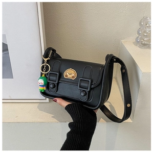 Detail of black crossbody bag with cute dog embroidery and cartoon charm accessory